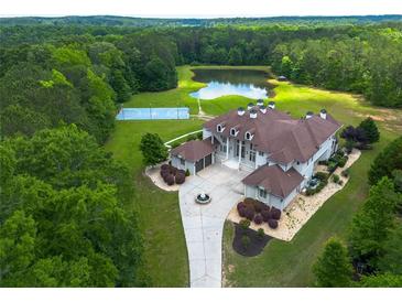 Stunning estate with manicured landscaping, private pond, and an outdoor sports court at 535 Waters Way, Fayetteville, GA 30215