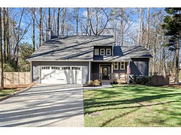 Charming home featuring a gray exterior, manicured lawn, two-car garage, and inviting front porch at 181 Arrowood Ln, Alpharetta, GA 30009
