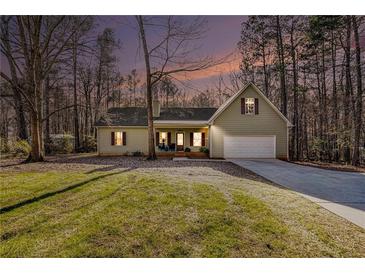 Charming single Gathering home with a well-manicured lawn, red shutters, and an attached garage at 305 Deep Step Rd, Covington, GA 30014