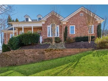 Charming brick home with dormers and covered porch, set on a beautifully landscaped lawn with retaining wall at 2850 Brandy Ln, Cumming, GA 30041