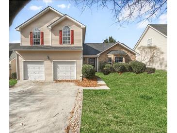 Charming two-story home with a two-car garage and well-maintained landscaping, red shutters, and symmetrical curb appeal at 4565 Bridle Point Pkwy, Snellville, GA 30039