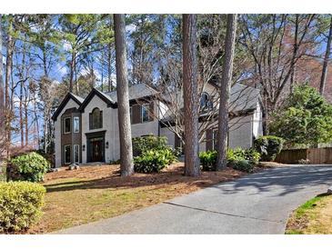 Traditional two-story home with a white brick exterior, dark trim, and mature landscaping at 203 Northside Nw Dr, Kennesaw, GA 30144