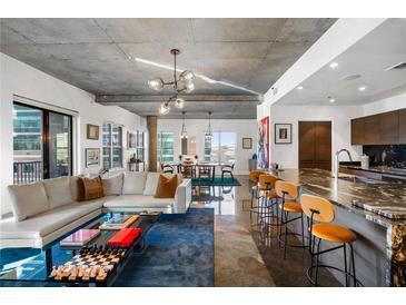 Bright and airy living room with a large sectional sofa and modern decor with a spacious kitchen in the background at 845 Spring Nw St # 502, Atlanta, GA 30308