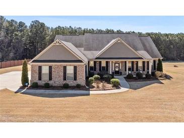 Charming single-story home featuring a manicured lawn, brick accents, and a welcoming front porch at 112 Standford Dr, Mcdonough, GA 30252