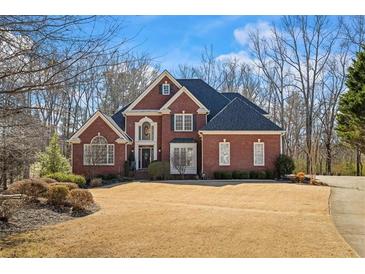 Beautiful brick home featuring a well-manicured lawn and professional landscaping at 7455 Richmond Way, Cumming, GA 30040