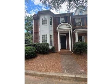 Inviting brick townhome with well-maintained landscaping and classic architectural details at 3851 Guilderoy Ln # 1, Austell, GA 30106