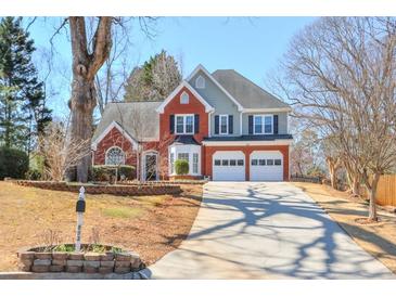 Charming two-story home with brick accents, attached two-car garage, and a long driveway at 893 Lance Cir, Lawrenceville, GA 30043