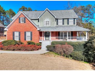 Charming two-story brick home with inviting front porch and well-maintained landscaping at 3064 Zermatt Way, Snellville, GA 30078