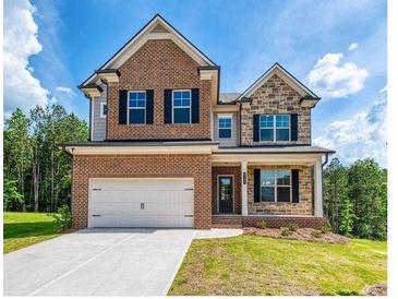 Charming brick and stone two-story home with a well-manicured lawn at 3194 Ivy Farm Path, Buford, GA 30519