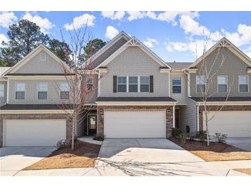 Charming townhome featuring a two-car garage, inviting entrance, and attractive exterior details at 2628 Wild Laurel Ct, Norcross, GA 30071