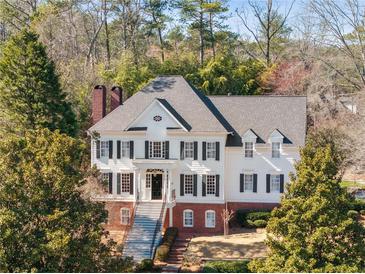 Elegant two-story home featuring black shutters, a brick foundation, and a welcoming front porch with staircase at 4399 Jett Nw Pl, Atlanta, GA 30327