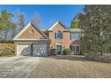 Charming brick home with a well-manicured front yard and a two-car garage at 9185 Brockham Way, Alpharetta, GA 30022