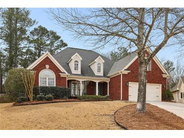 Charming two-story brick home with a well-manicured front yard and attached two-car garage, showcasing classic curb appeal at 172 Sweet Branch Ct, Grayson, GA 30017