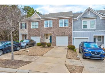 Townhome exterior showcasing brick facade, attached garages, and well-manicured landscaping at 6356 Kennonbriar Ct, Lithonia, GA 30058