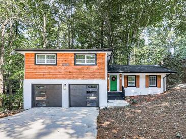 Charming updated home with a two-car garage, cedar siding, and a vibrant green front door at 1564 Bubbling Creek Rd, Brookhaven, GA 30319