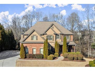 Beautiful two-story home featuring a brick and siding exterior with manicured landscaping and a charming front entrance at 5245 Wilshire Xing, Cumming, GA 30040