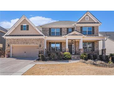 Charming brick home featuring a covered porch, two car garage and manicured landscaping at 2435 Portsmouth Ct, Marietta, GA 30064