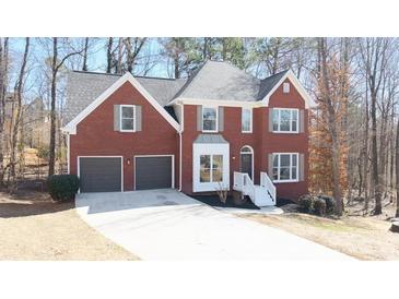 Charming two-story red brick home with a well-manicured front yard and attached two-car garage at 724 Eastwood Rise, Stone Mountain, GA 30087