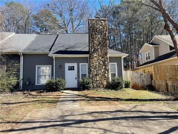 Charming home featuring a stone chimney, gray siding, and a well-maintained front yard at 1039 Whitfield Se Ct, Smyrna, GA 30080