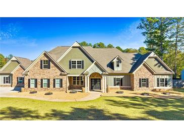 Charming home featuring a mix of brick and stone, complemented by black shutters and a well-manicured lawn at 650 New Morn Dr, Hampton, GA 30228