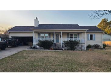 Charming single-story home features a covered porch, light shutters, and a well-maintained front yard at 3129 Rock Pine Way, Snellville, GA 30078