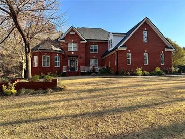 Charming two-story red brick home with a manicured lawn, a gabled roof, and a welcoming front entrance at 238 Chappell Rd, Fayetteville, GA 30215