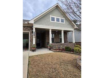 Charming brick home with a covered front porch and well-maintained landscaping at 3030 Appling Hills Dr, Dacula, GA 30019