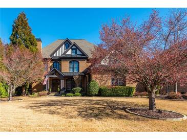 Stately brick home boasts mature trees, manicured landscaping, and an inviting facade with architectural details at 5175 Wilshire Xing, Cumming, GA 30040