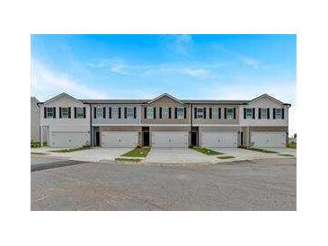 Newly constructed townhomes feature attached garages and neutral exteriors at 8664 Webb Rd, Riverdale, GA 30274