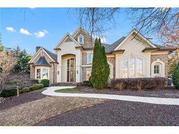 Elegant brick and stucco home featuring a graceful walkway, manicured landscaping, and architectural details at 2679 Wynnton Dr, Duluth, GA 30097