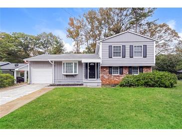 Charming two-story home featuring a manicured lawn, garage, and inviting front entrance at 3390 Navaho Se Trl, Smyrna, GA 30080