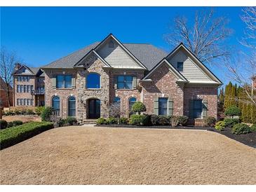 Charming brick home boasts a manicured lawn, stone accents, and a welcoming entrance at 942 Heathchase Dr, Suwanee, GA 30024