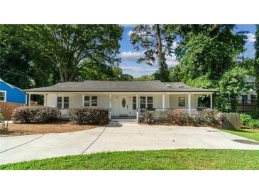 Charming home with a welcoming front porch, manicured landscaping, and a long driveway at 1551 Avon Ave, Atlanta, GA 30311