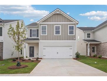 Charming two-story home featuring neutral siding, well-manicured lawn, and a two car garage at 2019 Wyndham Pl, Conyers, GA 30013