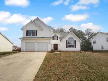 Charming two-story home featuring a two-car garage and landscaped front yard at 4200 Flakes Mill Manor Ln, Ellenwood, GA 30294