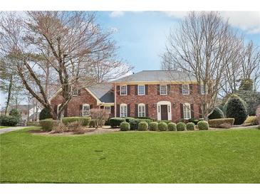 Charming brick two-story home with manicured front lawn and mature trees at 5275 Redfield Ct, Atlanta, GA 30338