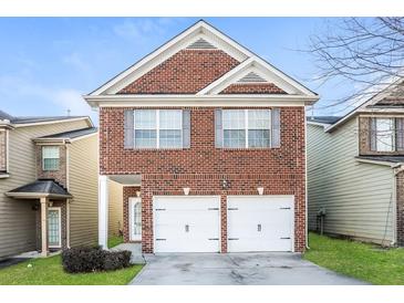 Charming two-story brick home with an attached two-car garage and well-maintained lawn at 3641 Oakleaf Pass, Fairburn, GA 30213
