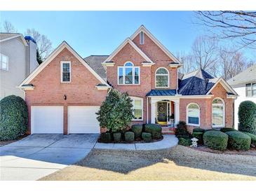 Charming brick two-story home featuring a two-car garage and meticulously landscaped front yard at 1301 Dayspring Trce, Lawrenceville, GA 30045