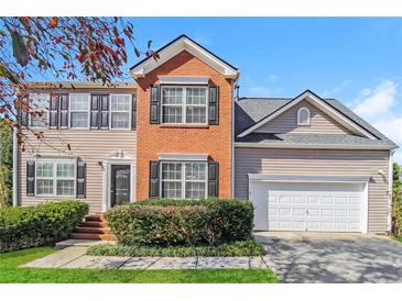 Charming two-story home featuring a brick facade, black shutters, and well-maintained landscaping at 603 Stonecrest Dr, Loganville, GA 30052