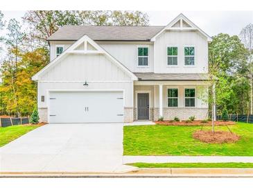 Charming two-story home with a well-manicured lawn and attached two-car garage at 142 Henley St, Canton, GA 30114