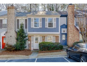 Charming two-story townhome featuring a cozy front yard with lovely landscaping and assigned parking at 6606 Wellington Sq, Norcross, GA 30093