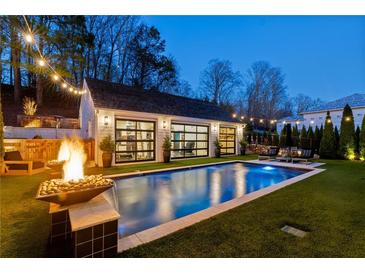 Backyard pool and pool house with string lights, fire bowls and ample seating for outdoor relaxation and entertainment at 7165 Cordery Rd, Cumming, GA 30040