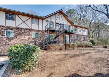 Charming two-story brick building featuring a staircase to upper-level patios and mature landscaping at 1229 Church St # C, Decatur, GA 30030