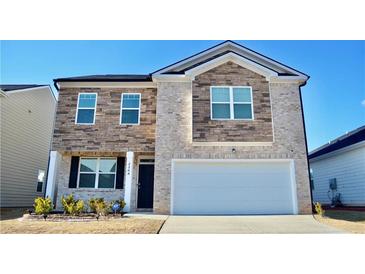 Charming two-story home with stone and brick exterior, a manicured lawn, and a two-car garage at 2268 Redfern Rd, Dacula, GA 30019
