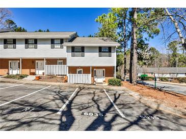 Inviting townhouse featuring a well-maintained facade, parking, and charming front entrances at 6035 Wintergreen Rd, Norcross, GA 30093