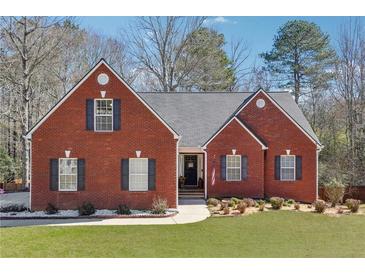 Charming red brick home with a well-manicured lawn and inviting entrance at 509 Plantation Creek Dr, Loganville, GA 30052