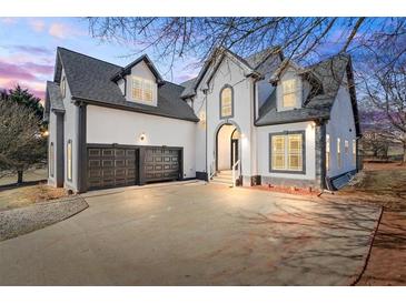 Stunning home exterior with a two-car garage, manicured lawn, and elegant architectural details at 3955 Pucketts Rd, Snellville, GA 30039