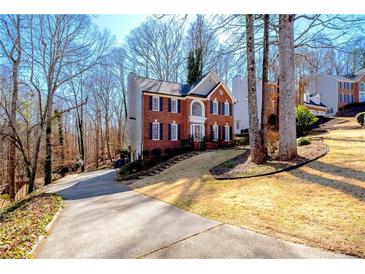 Charming red brick home with black shutters, a well manicured lawn and a long driveway at 450 Congress Pkwy, Lawrenceville, GA 30044