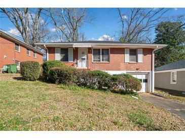 Charming brick home featuring an attached garage and landscaped front yard at 853 Erin Sw Ave, Atlanta, GA 30310