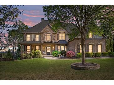 Beautiful two-story home with a stone and brick facade, a covered porch and meticulously manicured lawn at 330 Tupelo Trl, Canton, GA 30114